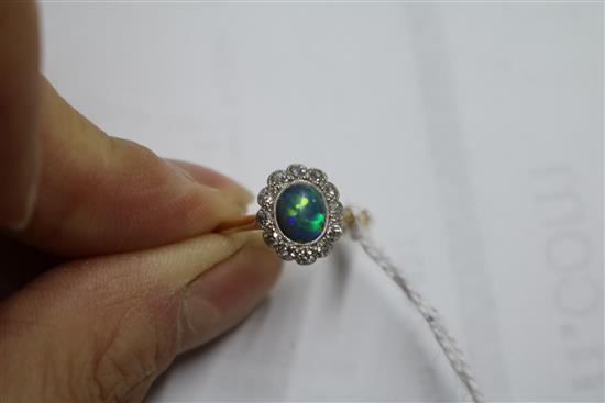 An 18ct gold and platinum, black opal and diamond cluster oval ring, size L.